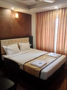 昆达普拉Hotel Samudyatha Inn And Suites的一间卧室配有一张大床和毛巾