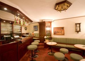 维斯马莱茵哈德酒店的一间带绿色椅子的餐厅以及一间带水槽的酒吧