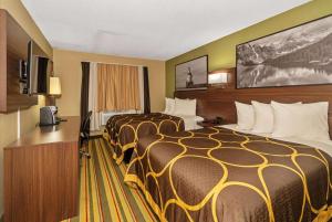 苏必利尔Super 8 by Wyndham Superior WI的酒店客房设有两张床和电视。