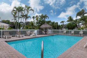 佛罗里达市佛罗里达市旅程住宿酒店的一个带椅子的游泳池、围栏和棕榈树