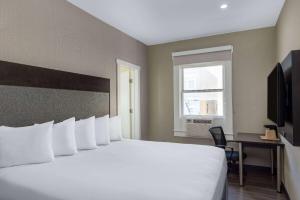 旧金山联合广场速8酒店的酒店客房设有一张白色大床和一个窗户。