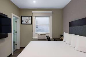 旧金山联合广场速8酒店的卧室设有一张白色大床和一扇窗户。