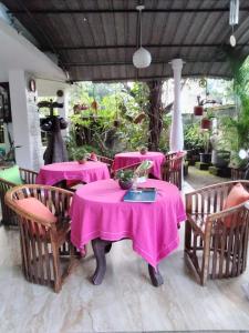 波隆纳鲁沃Rock Cascade tourist home的用餐室配有粉红色的桌椅