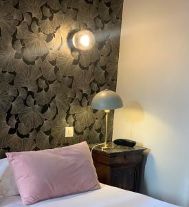 图尔米拉波酒店的一张带粉红色枕头的床和一张桌子上的台灯