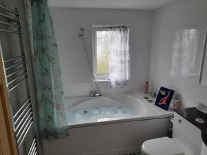 柯克宾Grovewood House Retreat的带浴缸和窗户的浴室
