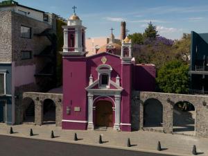 普埃布拉Banyan Tree Puebla的前面有鸽子的粉红色建筑
