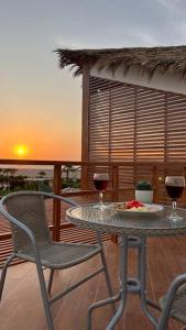 Casa BlancaHermosa casa con vista al mar的阳台上的桌子和两杯葡萄酒