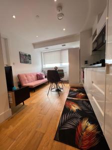克罗伊登Modern 1 bedroom apartment in the center of Croydon的客厅配有粉红色的沙发和地毯。