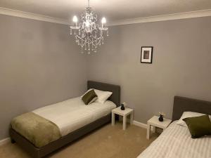 LemingtonBoss Breaks- Newcastle的一间卧室配有两张床和吊灯。