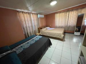 帕拉马里博Osso fu mi ati (huis van mijn hart)的一间带两张床的卧室,铺有瓷砖地板。