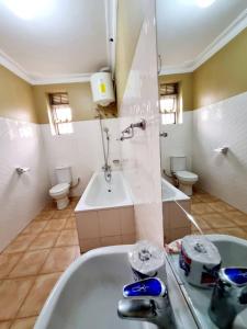 坎帕拉OCTA HOMES的带浴缸、水槽和2个卫生间的浴室