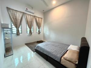关丹Homestay Ashad的一间卧室设有一张床和两个窗户。