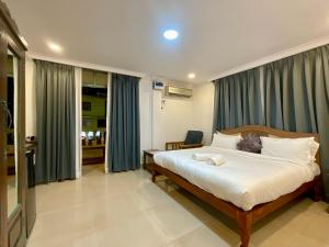 莫尔吉姆Nagas Hotel Satyavati Morjim的一间卧室配有一张带蓝色窗帘的大床