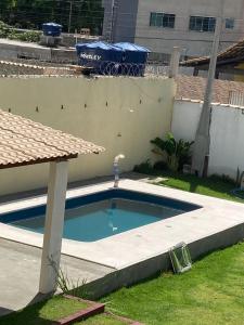 瓜拉派瑞POUSADA RECANTO DULE的一座小游泳池,位于大楼旁的院子内