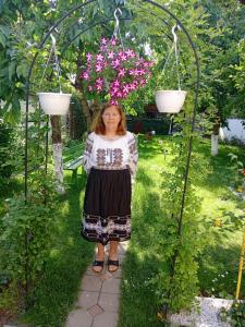 莱斯诺夫Apartamente Bucegi的女人站在种着花的花园中