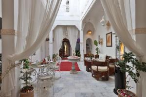 马拉喀什Riad Morocco Sky的客厅配有白色窗帘和桌椅