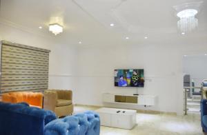 拉各斯Orchids Service apartments的客厅配有蓝色的沙发和电视
