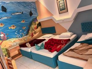 达哈布达哈卜海景酒店的一间设有两张床的客房,配有海洋绘画