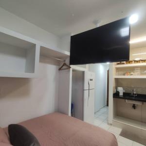 瓜拉派瑞Kitnet no centro de Guarapari的客房设有一张床和一台平面电视。