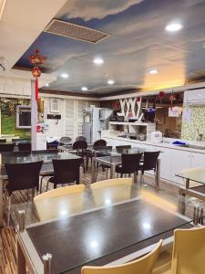 新竹Bin Chen Business Hotel的一间带桌椅的餐厅和一间厨房