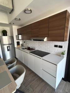 危地马拉EÓN 13 - Apto moderno con aire acondicionado的厨房配有白色橱柜和不锈钢冰箱
