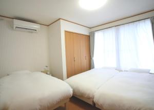 Takagiたび宿SeKKoku的带窗户的客房内的两张床