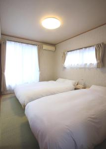 Takagiたび宿SeKKoku的酒店客房设有两张床和窗户。
