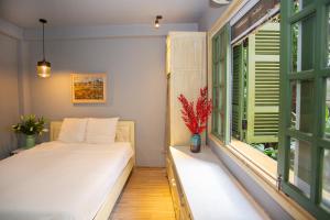 河内Chez Van的一间卧室设有床铺和一个带绿色百叶窗的窗户。