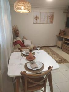 巴西利亚Apartamento Aconchegante的餐桌、两把椅子、白桌和酒杯