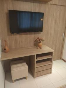 巴西利亚Apartamento Aconchegante的一张木桌,墙上有电视