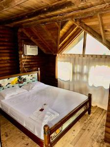 帕尔马岛Mistica Island Hostel - Isla Palma的木制客房内的一间卧室,配有一张床