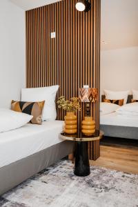 科隆S331 - Luxurious two bedroom duplex apartment in cologne的一间卧室设有两张床和一张带花瓶的桌子。
