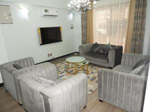 达累斯萨拉姆MJ Hosting的客厅配有两张沙发和一张桌子