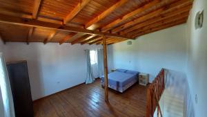 伊瓜苏港Ñandubay1的一间卧室设有一张床和木制天花板