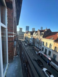 布鲁塞尔Immeuble au cœur de Bruxelles : Vivez l'Expérience Unique de la Rue Verbist的阳台享有城市街道的景致。