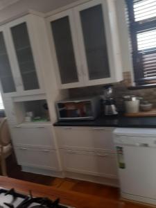 GqeberhaFun-filled, cosy family home的厨房配有白色橱柜和微波炉