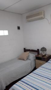 梅塞德斯La Baquiana 2的一间卧室配有一张床,还有一个带风扇的床头柜。