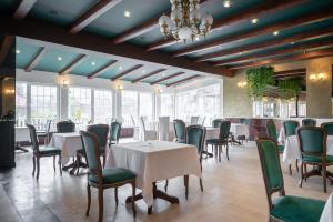 波亚纳布拉索夫Monterai Resort的用餐室配有白色的桌子和绿色的椅子