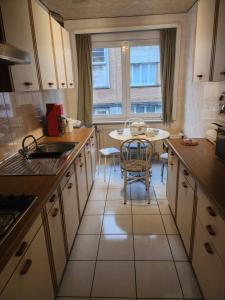 布鲁塞尔Appartement Parc Forestier 3-4 personnes的一间带桌子的厨房和一间餐厅