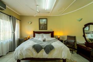 维多利亚瀑布Room in Villa - Zambezi Family Lodge - Lion Room的一间卧室配有一张大床和镜子