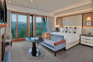 特拉基太浩湖丽思卡尔顿酒店的酒店客房配有床、沙发和桌子。