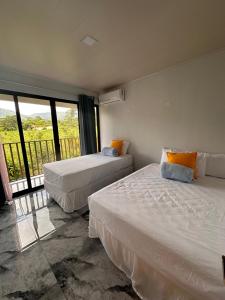 福尔图纳Luxury Villas Arenal的一间带两张床的卧室和一个阳台