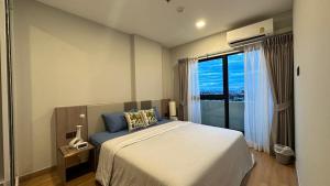 清迈Astra Sky River- Chiang Mai 1的一间卧室设有一张大床和一个大窗户