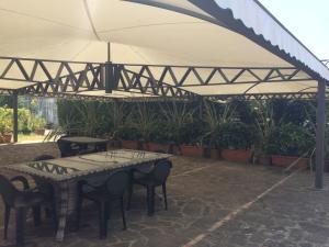 弗拉克维尔玛拉汀索西埃塔阿格里科拉MG弗洛普朗特酒店的帐篷下配有桌椅的天井