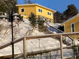 卢恩斯基尔贵族山林小屋的雪中的一个黄色房子,有楼梯