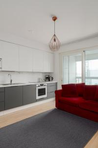 赫尔辛基New LUXUS 3BR Helsinki Home的一间带红色沙发的客厅和一间厨房
