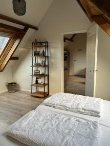 韦斯特卡佩勒Ruim appartement met sauna, Zuidstraat 125 in Westkapelle的阁楼间内的一张白色床