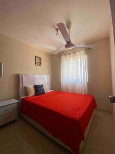 La JavillaSeguridad y tranquilidad Apartamento completo 3 camas 3 habitaciones !的一间卧室配有一张红色的床和吊扇