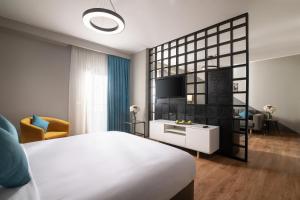十月六日城Dhara Residence E2 Lodge Hotel的卧室配有白色的床和电视。