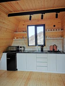 卡兹贝吉Arsha View的厨房配有白色橱柜和黑色冰箱。